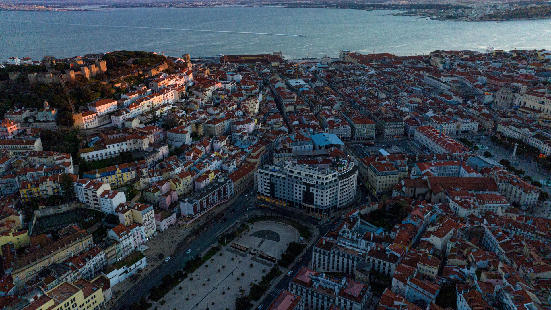 Aerial view of the city of Lisbon at sunset, with the Tagus River in the background